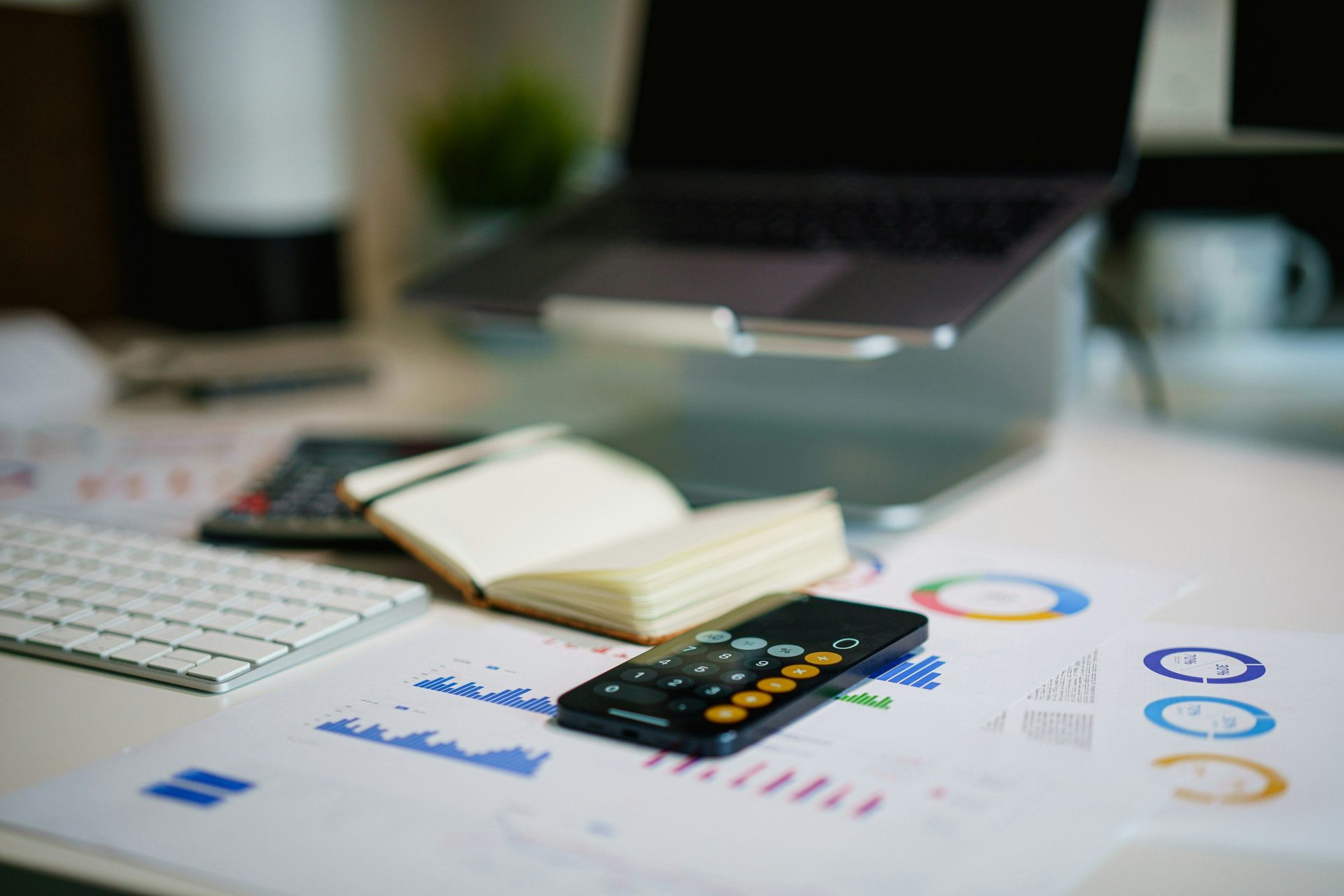 Büroschreibtisch mit Smartphone und Finanzdiagrammen